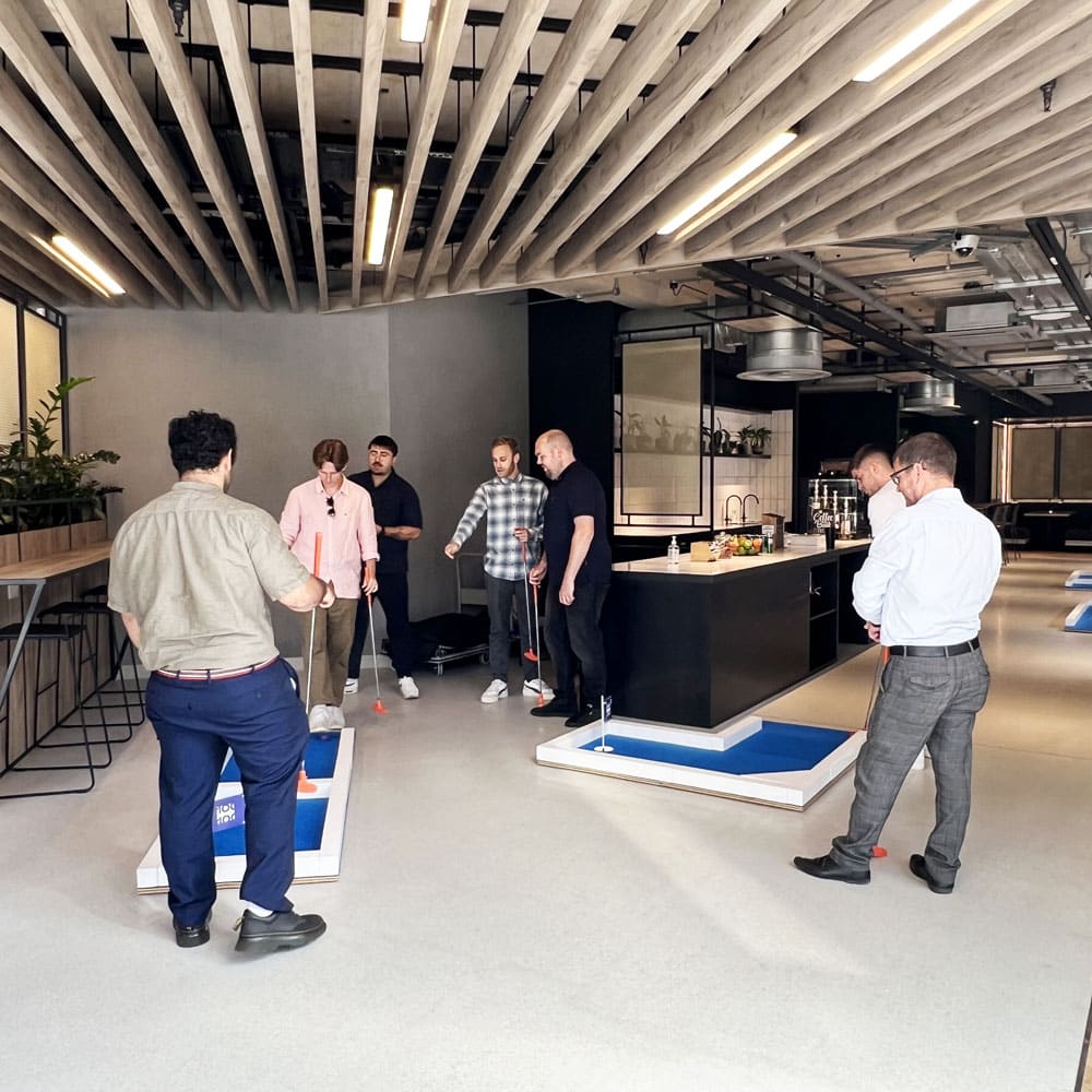 Colleagues playing crazy golf together during a work event