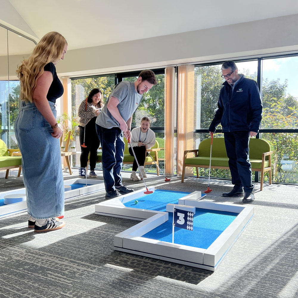 Team building event with colleagues playing office crazy golf